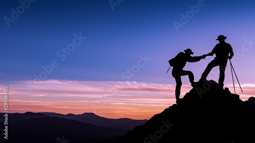 silhouette picture teamwork man helping hand friend to top of mountain successful with mountain background copy space twilight time