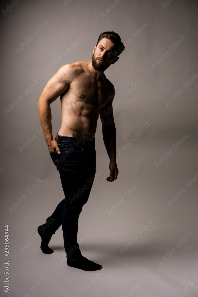 Fototapeta premium Closed up man pulling a comb on his back pocket. New jeans. Fit and handsome man. Putting something in his back pocket.