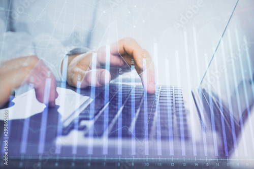 Double exposure of market chart with man working on computer on background. Concept of financial analysis.