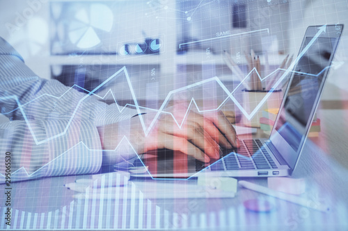 Double exposure of stock market graph with man working on laptop on background. Concept of financial analysis.