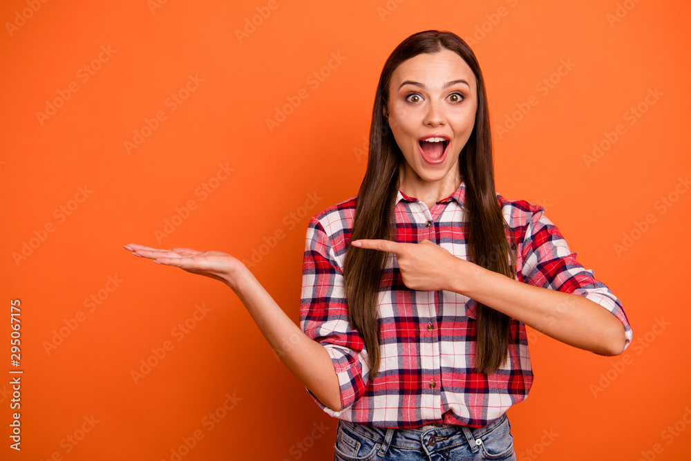Hot 50%off concept. Closeup photo portrait of pretty beautiful nice glad charming emotional lady holding empty space on palm showing forefinger wearing red shirt isolated bright color background Hot 50%off concept. Closeup photo portrait of pretty beautiful nice glad charming emotional lady holding empty space on palm showing forefinger wearing red shirt isolated bright color background
