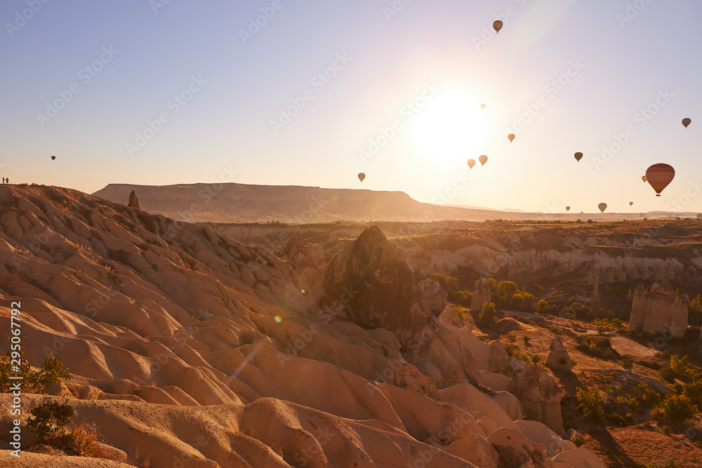 morning photo in Cappadocia with air balloons in the blue sky over sandy hills