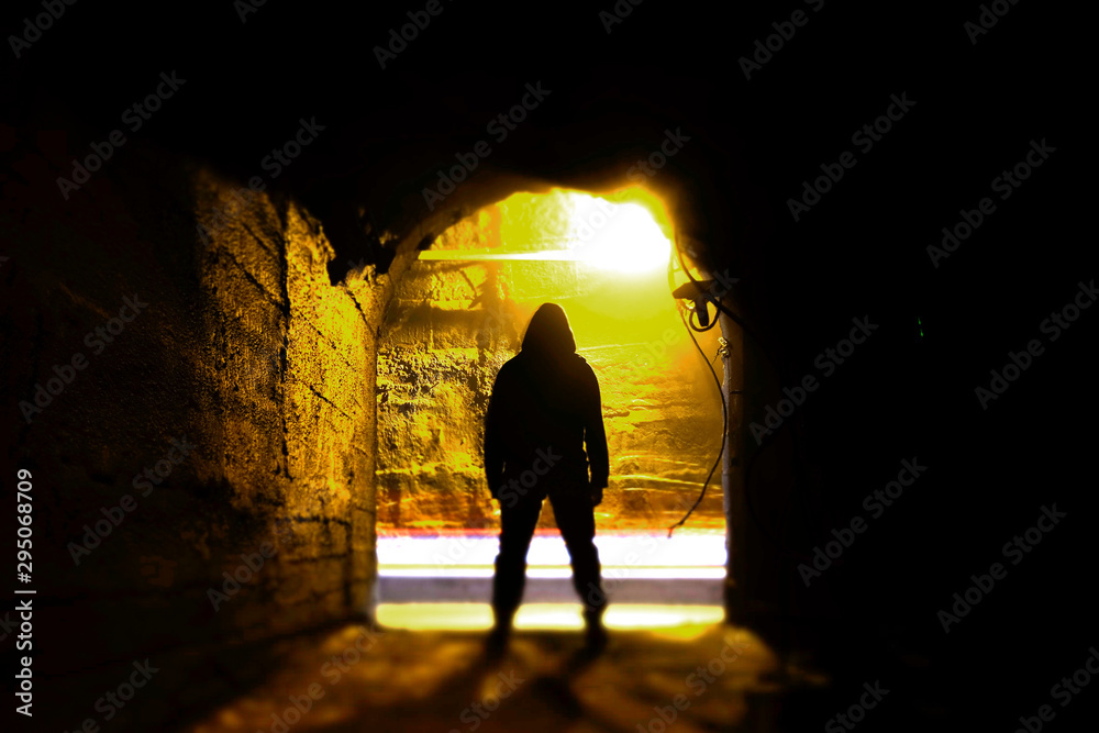 Fototapeta premium A man standing in an underground corridor. Man in tunnel