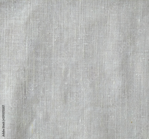 Dark white canvas with fold marks. Abstract background of crumpled cheesecloth. Close up   photo