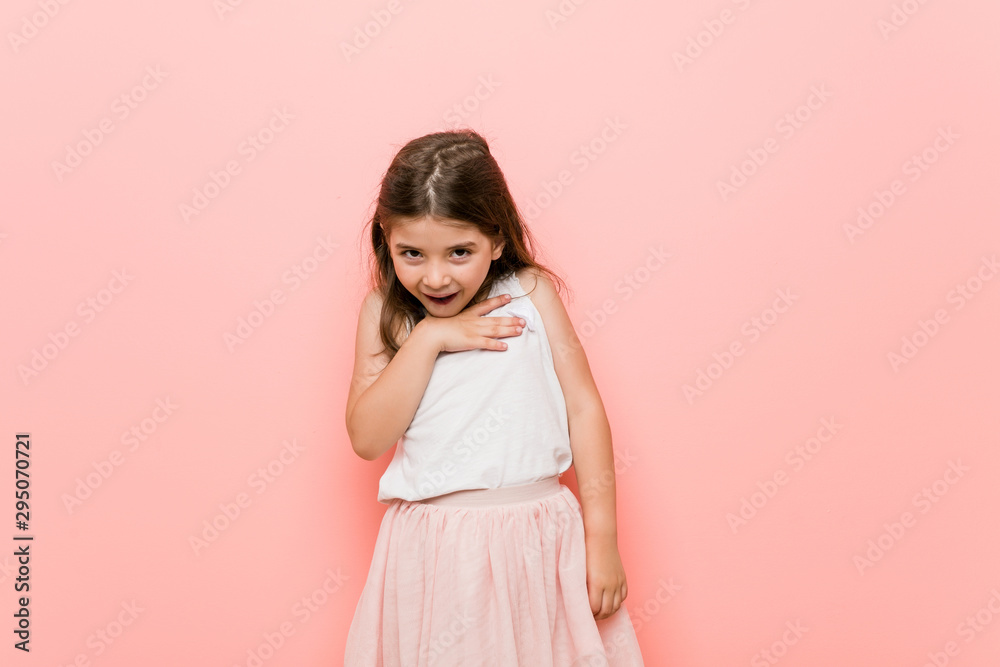 Little girl wearing a princess look laughs out loudly keeping hand on chest. Little girl wearing a princess look laughs out loudly keeping hand on chest.