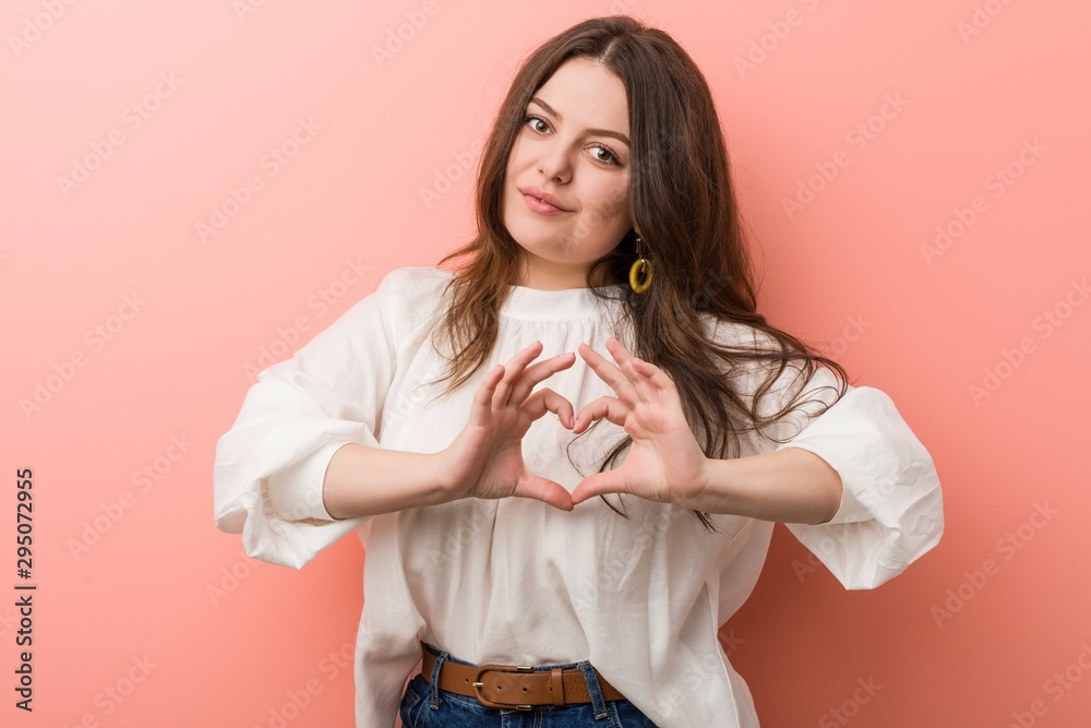 Young caucasian curvy woman standing against pink background Young caucasian curvy woman standing against pink background