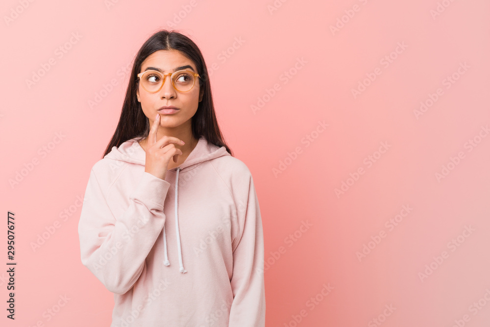 Young pretty arab woman wearing a casual sport look looking sideways with doubtful and skeptical expression. Young pretty arab woman wearing a casual sport look looking sideways with doubtful and skeptical expression.