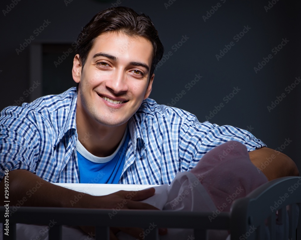 Happy dad looking after newborn baby at night