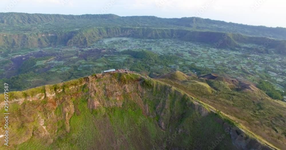 Birds eye view over magnificent and beautiful green cliffs of Batur,Indonesia showing hikers and trekkers chilling at a cafe on the top.Aerial ,Forward moving. Birds eye view over magnificent and beautiful green cliffs of Batur,Indonesia showing hikers and trekkers chilling at a cafe on the top.Aerial ,Forward moving.
