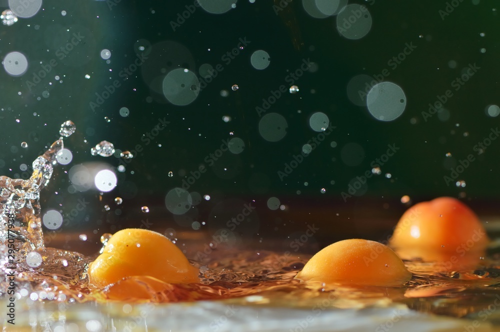 Fototapeta premium Peach nectarines fall from above into the water. Fruit washing, cooking.