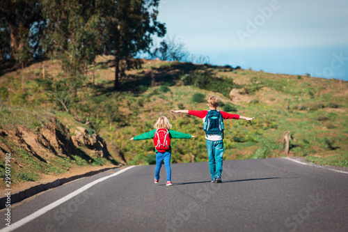 Happy boy and girl enjoy travel on road in mountains