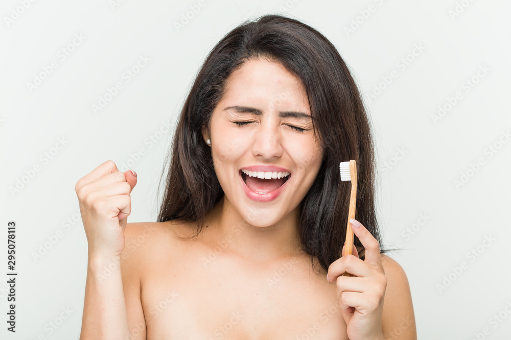 Young hispanic woman holding a toothbrush cheering carefree and excited. Victory concept. Young hispanic woman holding a toothbrush cheering carefree and excited. Victory concept.