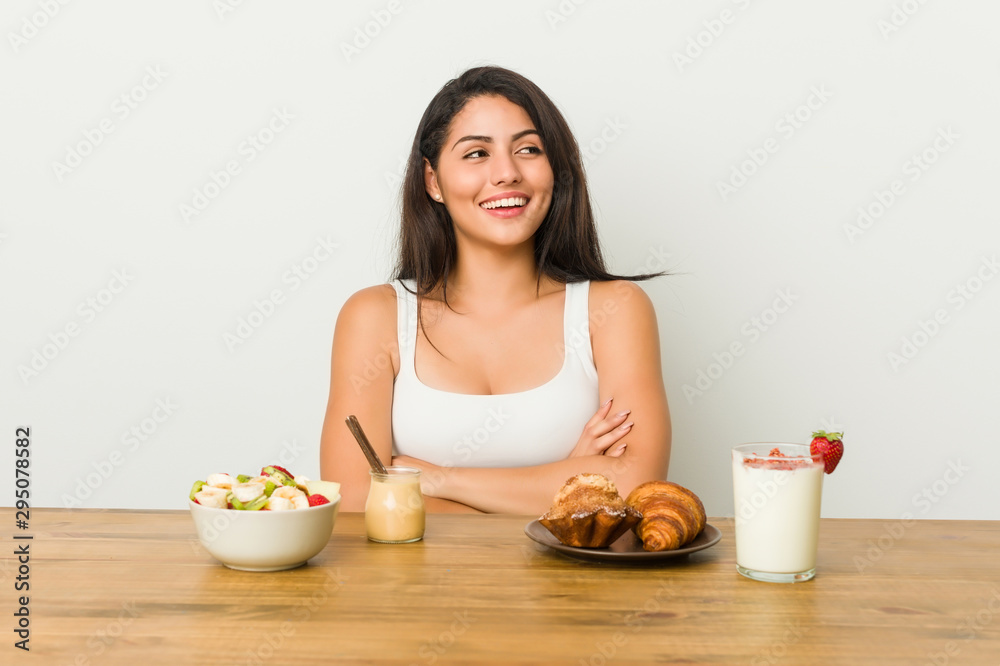 Young curvy woman taking a breakfast smiling confident with crossed arms. Young curvy woman taking a breakfast smiling confident with crossed arms.