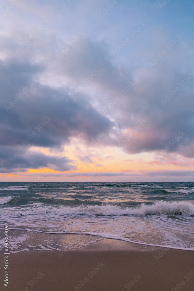 sea by the sandy beach at sunset in purple light