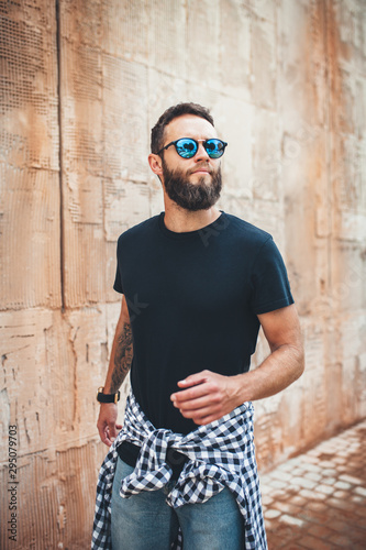 Handsome hipster man with beard wearing black blank t-shirt with space for your logo or design. black t shirt mockup.