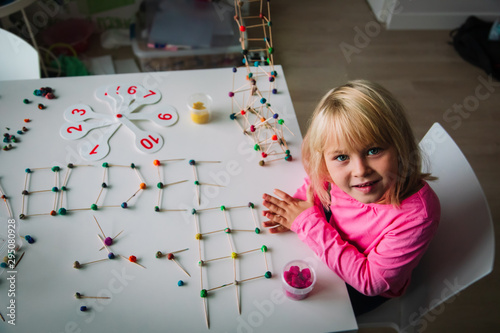 girl making letters, geometric shapes from sticks and clay, engineering and STEM