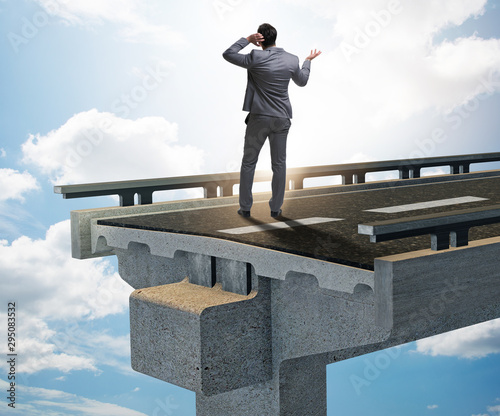 Businessman in uncertainty concept with broken bridge