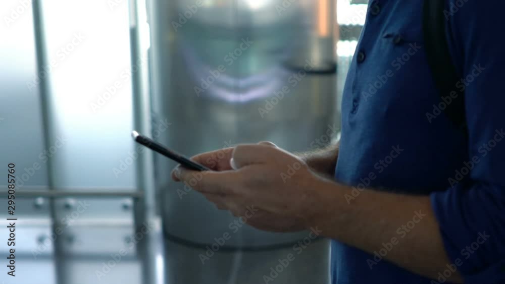 Man, tourist texting on smartphone walking at the airport Man, tourist texting on smartphone walking at the airport