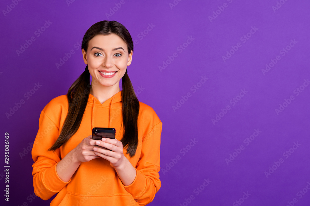 Portrait of lovely positive cheerful youth girl addicted blogger use her mobile phone share post blogs on her social network account wear sportswear isolated over violet purple color background Portrait of lovely positive cheerful youth girl addicted blogger use her mobile phone share post blogs on her social network account wear sportswear isolated over violet purple color background