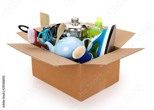 Moving house cardboard box filled with household and kitchen utilities, isolated on white background. Contains clipping path.
