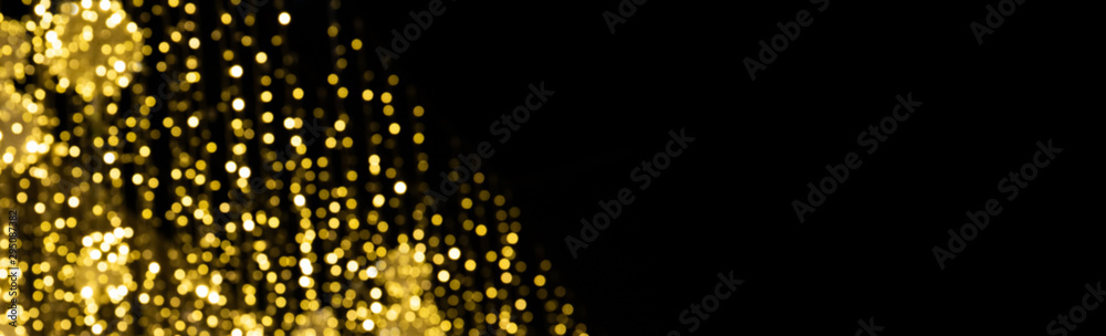 Magic shiny bokeh lights background, fantastic abstract pattern. Beautiful golden glowing Christmas decoration on black
