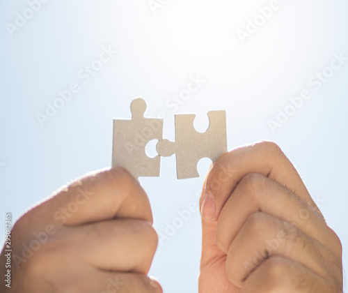 Hands holding puzzle pieces