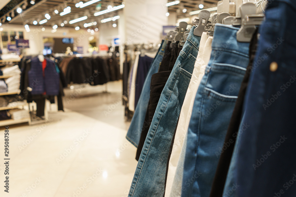 Fashionable clothes on hangers in a store.