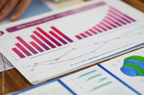 Close-up of biz documents with statistics data in charts, graphs and diagrams. Financial forecast of growth income. Stock Exchange, Securities Market concept. Blurred background photo