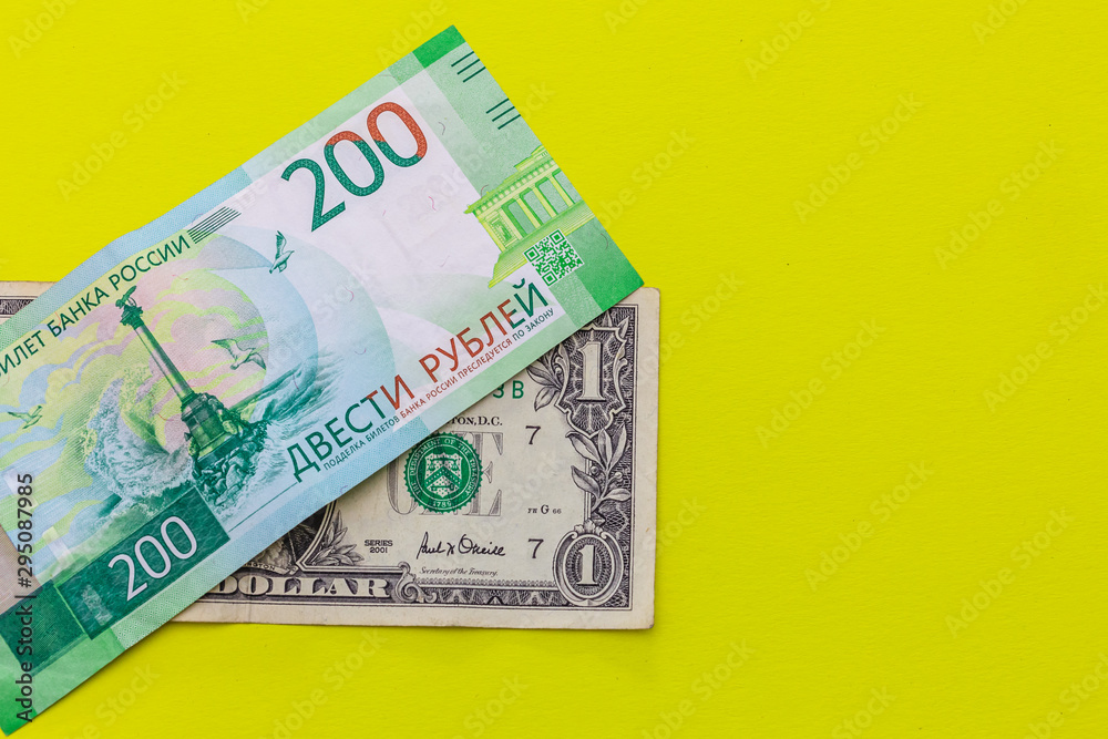 Obraz premium 1 dollar and 200 rubles on yellow background. Place for text.