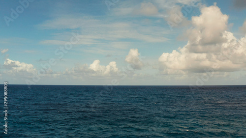 Blue ocean with waves and blue skies with clouds. Blue water and sky landscape, top view. Water cloud horizon background.