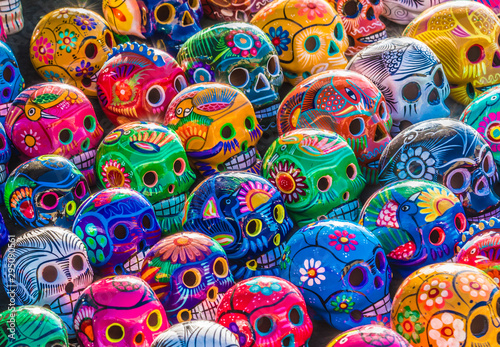 Mexican Culture Fiesta: Colorful (colourful) traditional Mexican/hispanic painted ceramic pottery Day of the Dead (Dia de los Muertos) skulls on display at a market in Mexico. 