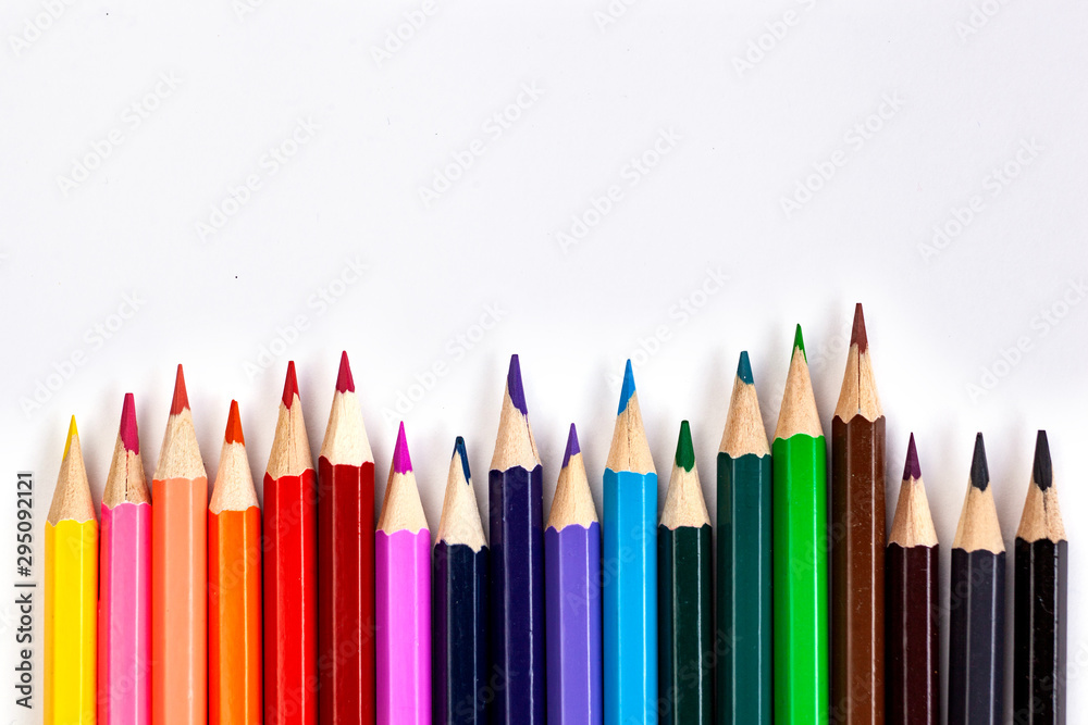 Set of colored pencils at the bottom of the frame in a row on a white background. Flat lay style. Set of colored pencils at the bottom of the frame in a row on a white background. Flat lay style.