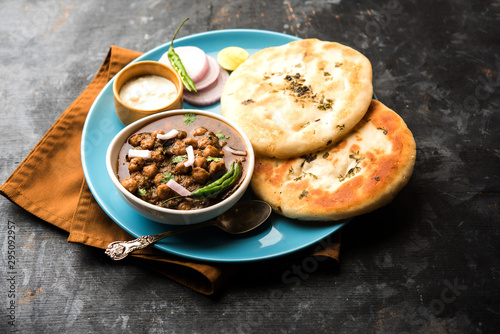 Pindi Chole Kulche or roadside choley Kulcha popular in India and pakistan is a popular streetfood. It's a spicy Chickpea or chana curry served with Indian Flat Bread. selective focus