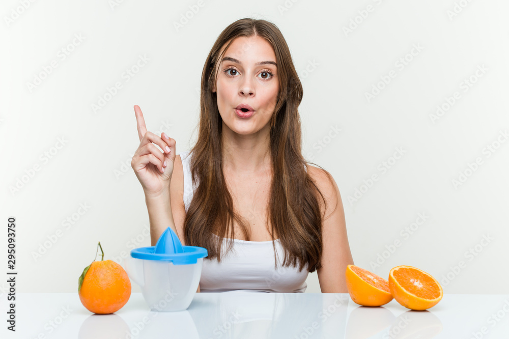 Young caucasian woman with an orange juicer having some great idea, concept of creativity. Young caucasian woman with an orange juicer having some great idea, concept of creativity.