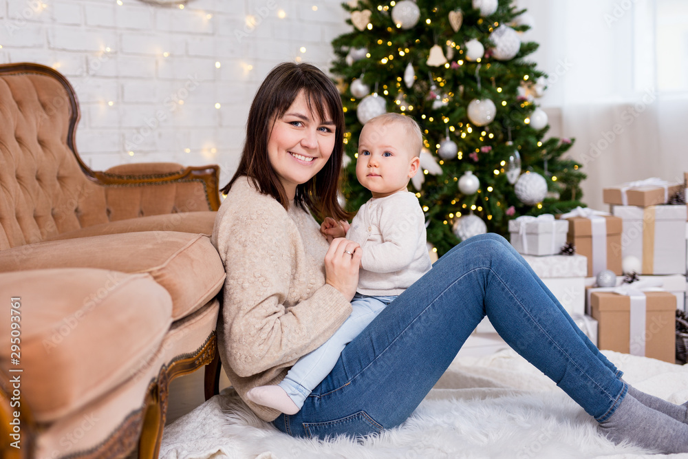 Obraz premium christmas, happiness and family concept - portrait of happy mother and little daughter near decorated christmas tree