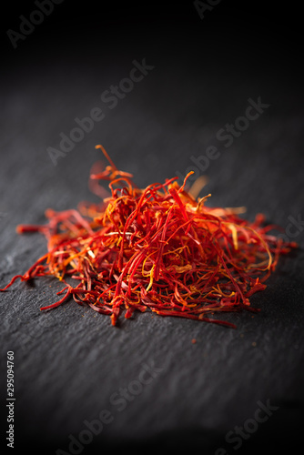 Saffron threads flower spice macro on black slate stone board