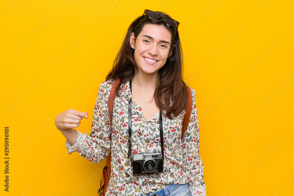 Young brunette traveler woman person pointing by hand to a shirt copy space, proud and confident Young brunette traveler woman person pointing by hand to a shirt copy space, proud and confident