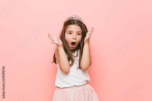 Little girl wearing a princess look celebrating a victory or success, he is surprised and shocked.