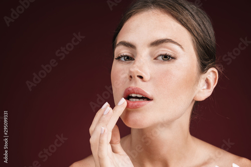 Image of adorable shirtless woman looking at camera and touching her lips