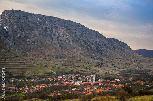 The rural village of Rametea (Torocko) and Piatra Secuiului (Szekelyko) Mountain in the background, in Alba County, Transylvania region, Romania