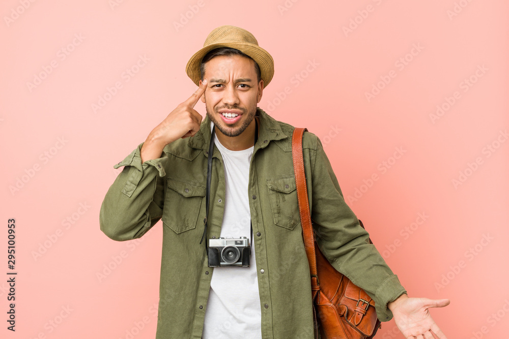 Young filipino traveler man showing a disappointment gesture with forefinger. Young filipino traveler man showing a disappointment gesture with forefinger.