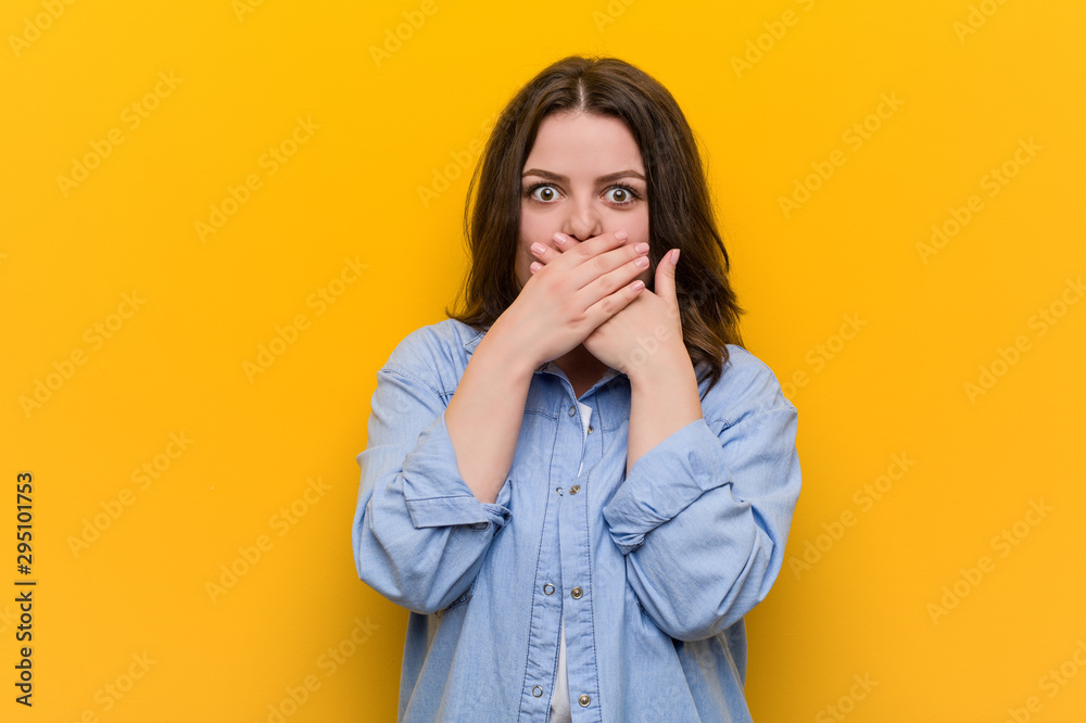 Young curvy plus size woman shocked covering mouth with hands. Young curvy plus size woman shocked covering mouth with hands.