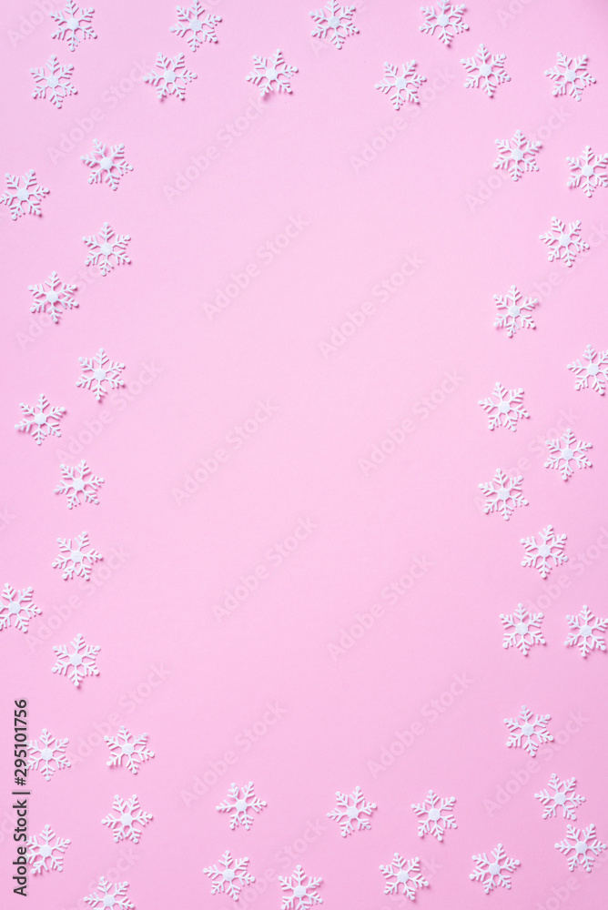 Winter composition. Christmas, new year concept. Top view. Flat lay. Winter pattern made of white snowflakes on pink background. Winter composition. Christmas, new year concept. Top view. Flat lay. Winter pattern made of white snowflakes on pink background.