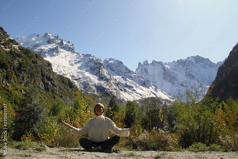 Fototapeta premium Woman meditating yoga in mountain gorge. Travel. Lifestyle. Relaxation. Emotional concept. Outdoor adventure. Harmony with nature.