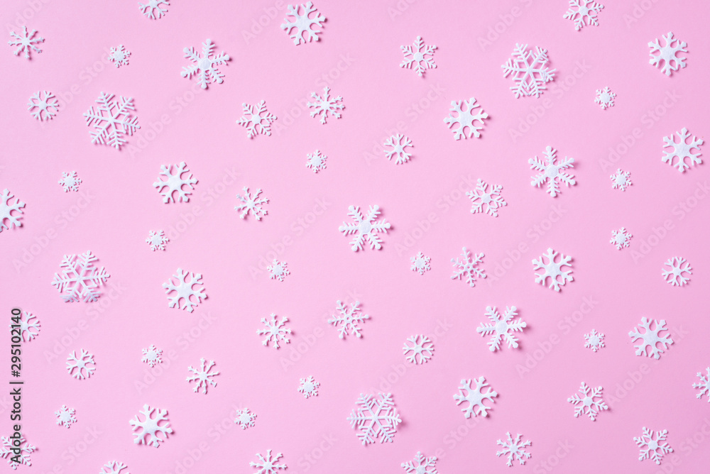 Winter pattern made of white snowflakes on pink background. Top view. Flat lay. Winter composition. Christmas, new year concept. Winter pattern made of white snowflakes on pink background. Top view. Flat lay. Winter composition. Christmas, new year concept.
