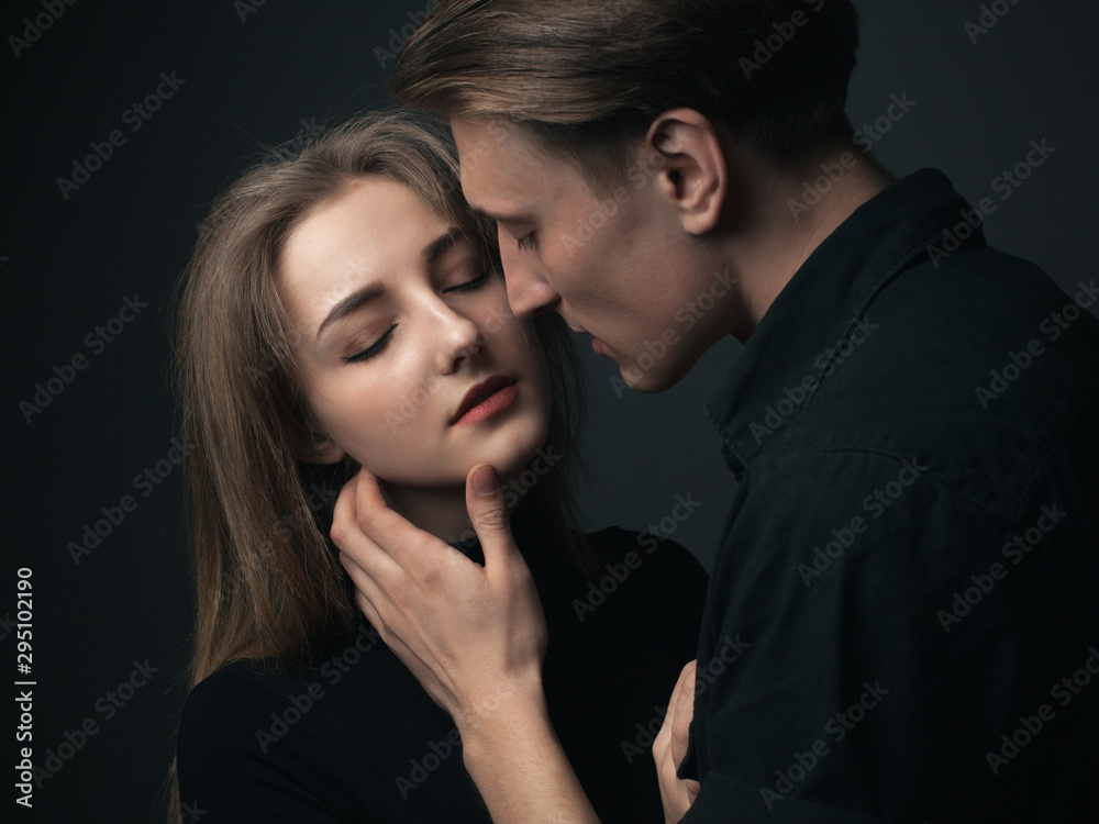 Young couple in love kissing in studio. Low key. Young couple in love kissing in studio. Low key.