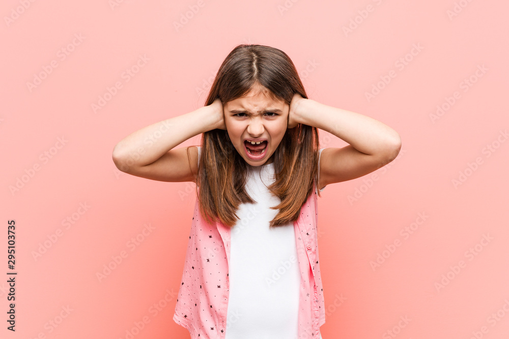 Cute little girl covering ears with hands trying not to hear too loud sound. Cute little girl covering ears with hands trying not to hear too loud sound.
