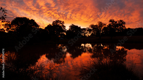 Red sunrise on lake with reflections