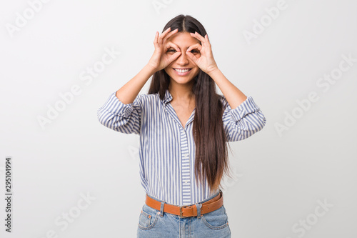 Young pretty arab woman showing okay sign over eyes