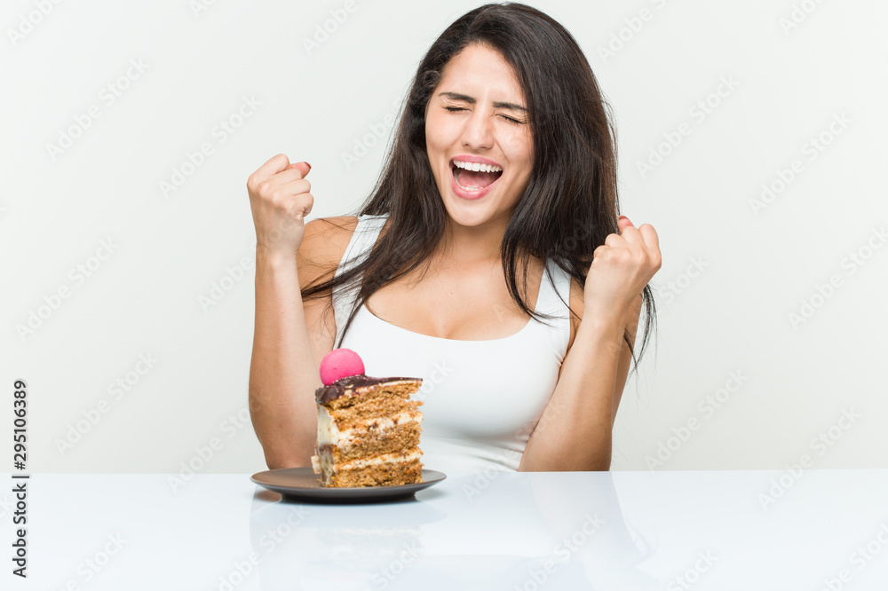 Young hispanic woman eating a cake cheering carefree and excited. Victory concept. Young hispanic woman eating a cake cheering carefree and excited. Victory concept.